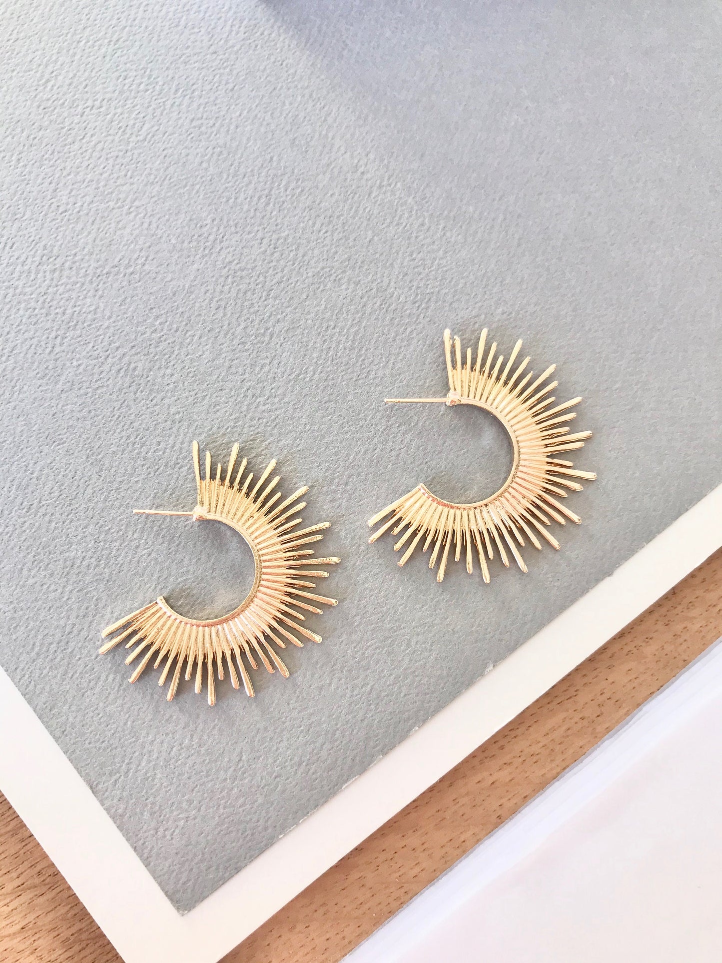 Gold starburst hoop earrings